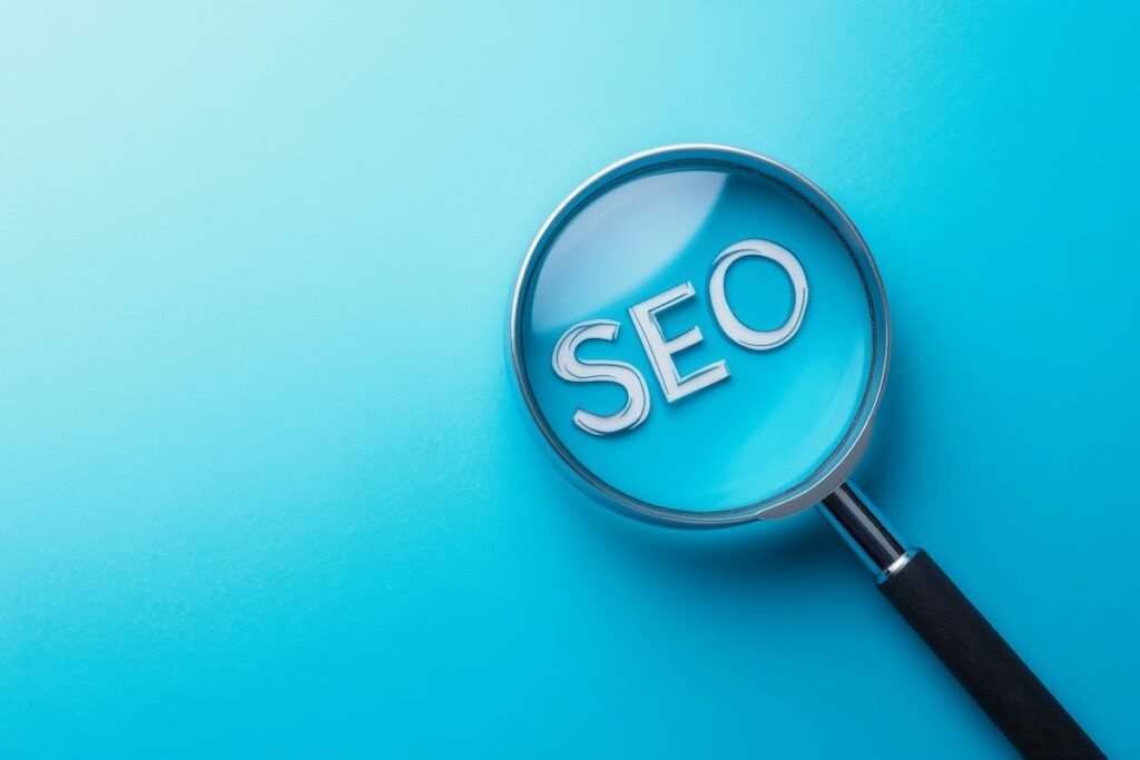 SEO-Analyse und SEO-Strategie werden symbolisiert durch eine Lupe, die über dem Wort SEO steht.