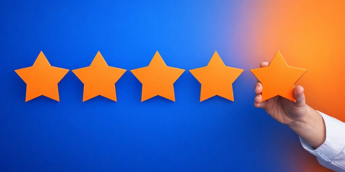 Bewertungsmanagement mit fünf orangefarbenen Sternen auf blauem Hintergrund, wobei ein Stern hervorgehoben gehalten wird – Symbol für strukturierte Vertrauenssignale und systematische Online-Reputation in Such- und KI-Systemen.